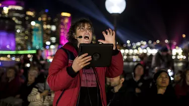 A woman provides an audio-described tour of the Opera House to hearing impaired patrons.