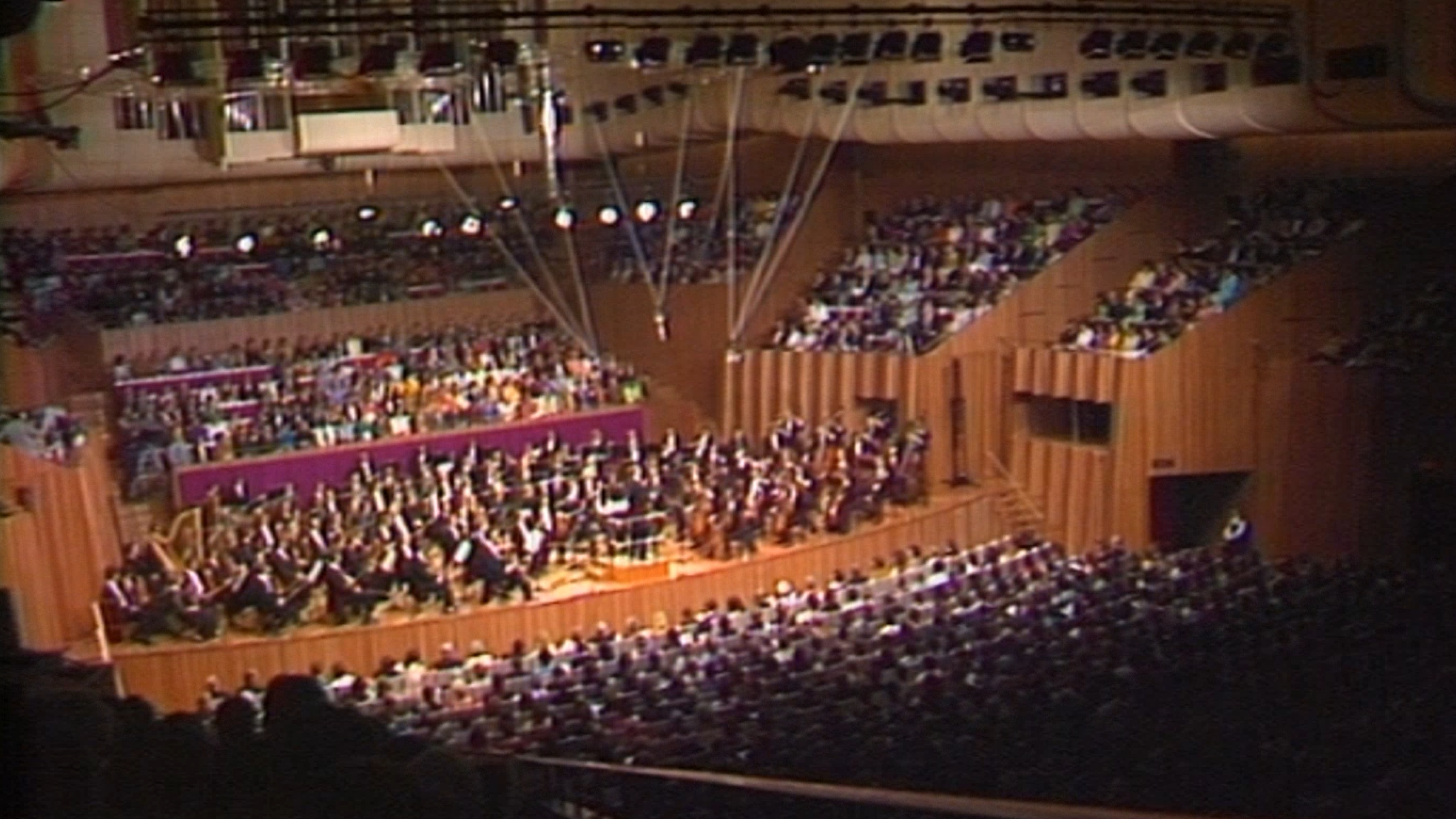 An orchestra playing on stage in the Concert Hall, as viewed from the back of the hall.
