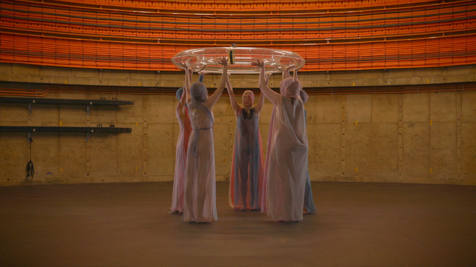 A group of women holding a swim ring above their heads in a circle.