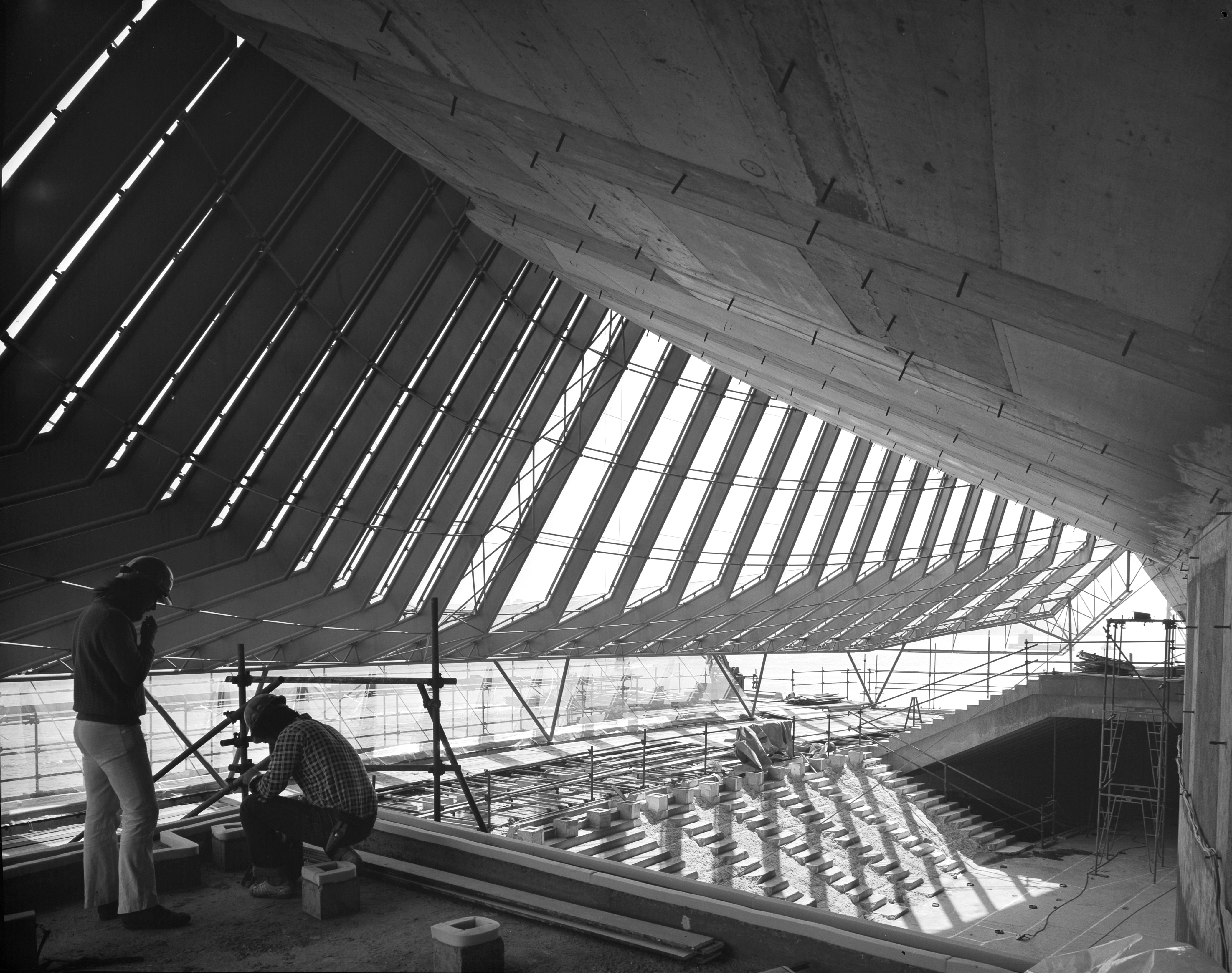 Two men working on the interior construction of the Sydney Opera House.