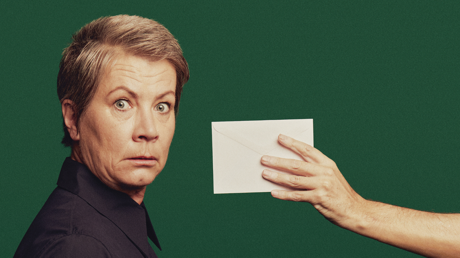 A blonde woman looking shocked after seeing a letter.