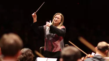 Simone Young conducts with baton in the hand in front of an orchestra