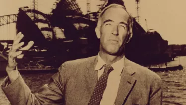 A collage in sepia of a man in a suit standing in front of the Opera House under construction, the harbour and the Sydney Harbour Bridge in the background.