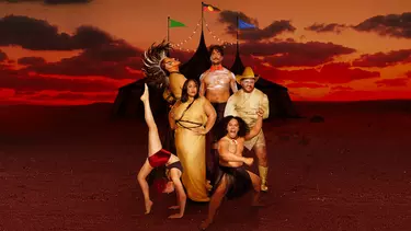 A group of indigenous men and women wearing circus costumes.