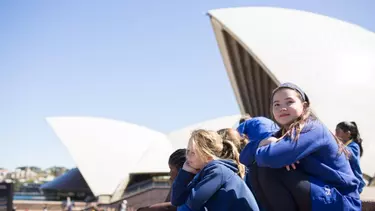 School girls sitting outside on the stairs of the Sydney opera house.