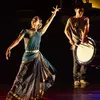 A woman in an Indian saree dancing to the sound of a Japanese drum