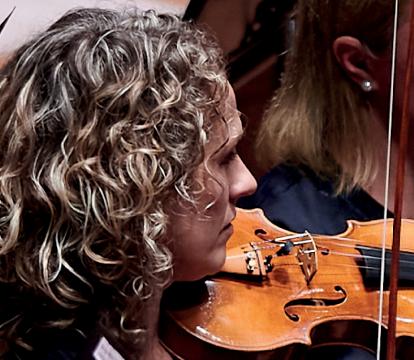 A woman with curly hairs playing a violin.