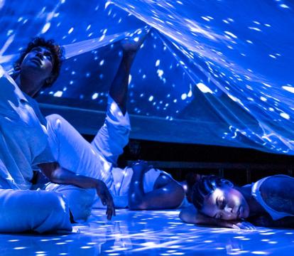 First Nation dancers under a starry sky.