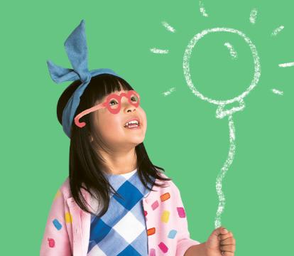 An Asian girl holding a pretend balloon which is glowing.