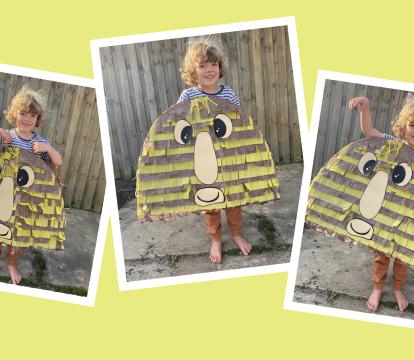 Child holding up a stripy crafted cardboard grug.
