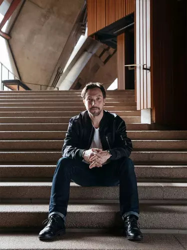 Ben Marshall Head Of Contemporary Music at Sydney opera house sitting on the staircase.
