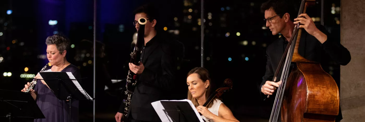 A horn, bassoon, cello, and double bass musician play in the Utzon Room