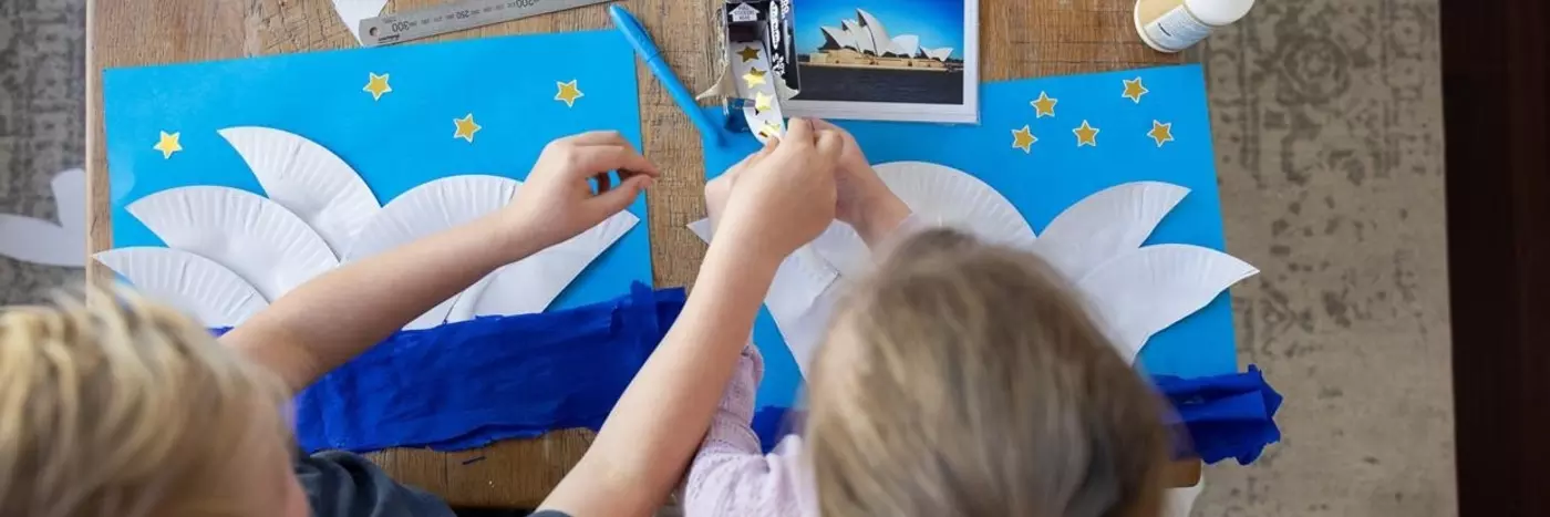 Kids creating sails of the Sydney opera house by cutting paper plates.