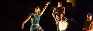 A woman in an Indian saree dancing to the sound of a Japanese drum