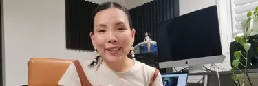 Singer Dami Im speaks direct to camera, sitting next to a keyboard