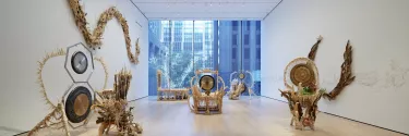 In a long room with white walls and a floor to ceiling window features cream and beige sculptures representing the artists battle with cancer.