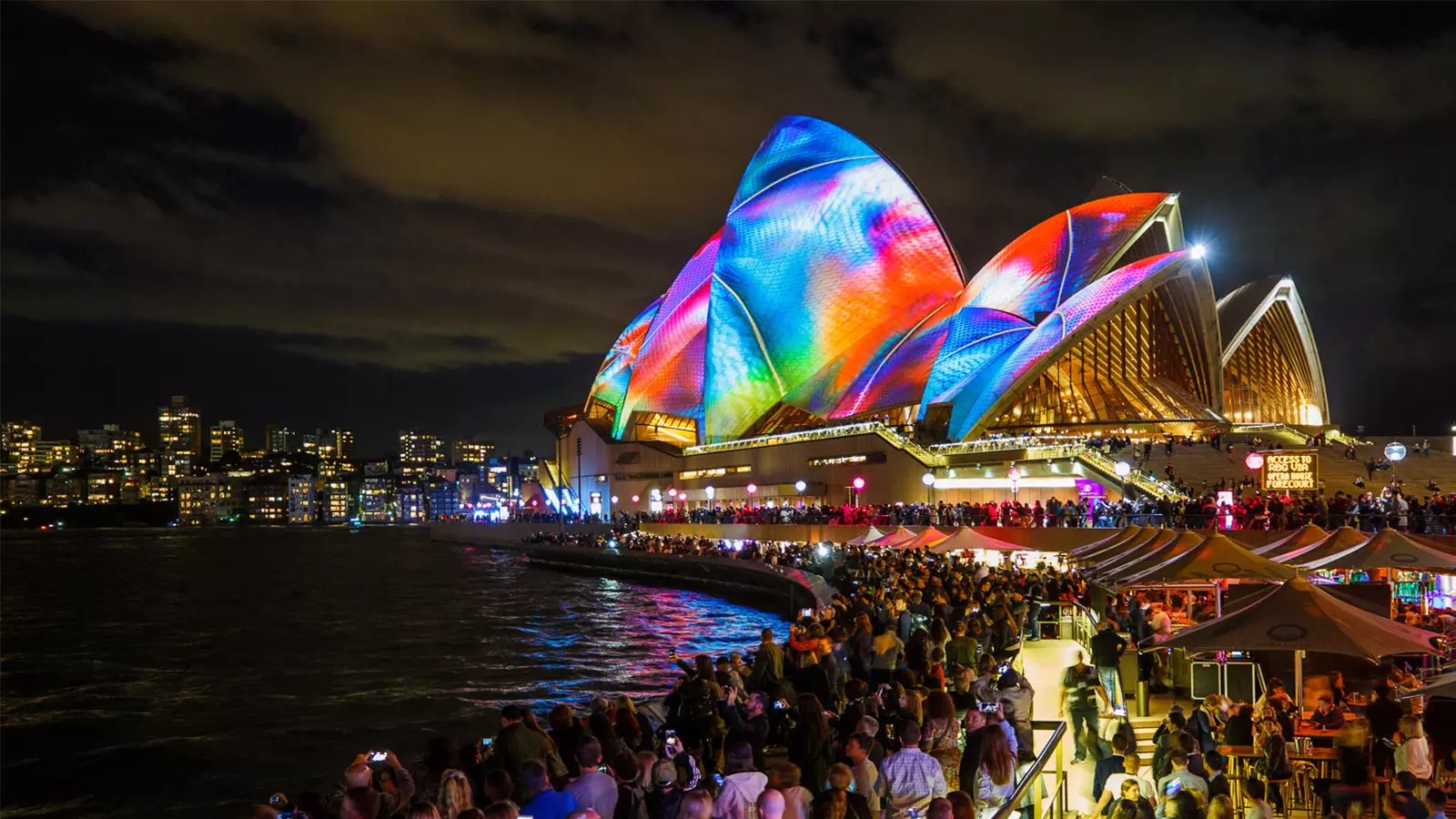 The Sydney Opera House lit up with colourful lights.